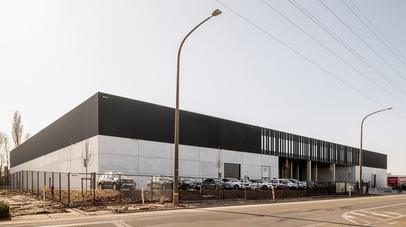 Langgerekt bedrijfsgebouw met metalen gevelbekleding en betonstructuur langs de straat in Oudenaarde | © Michiel Vergauwe