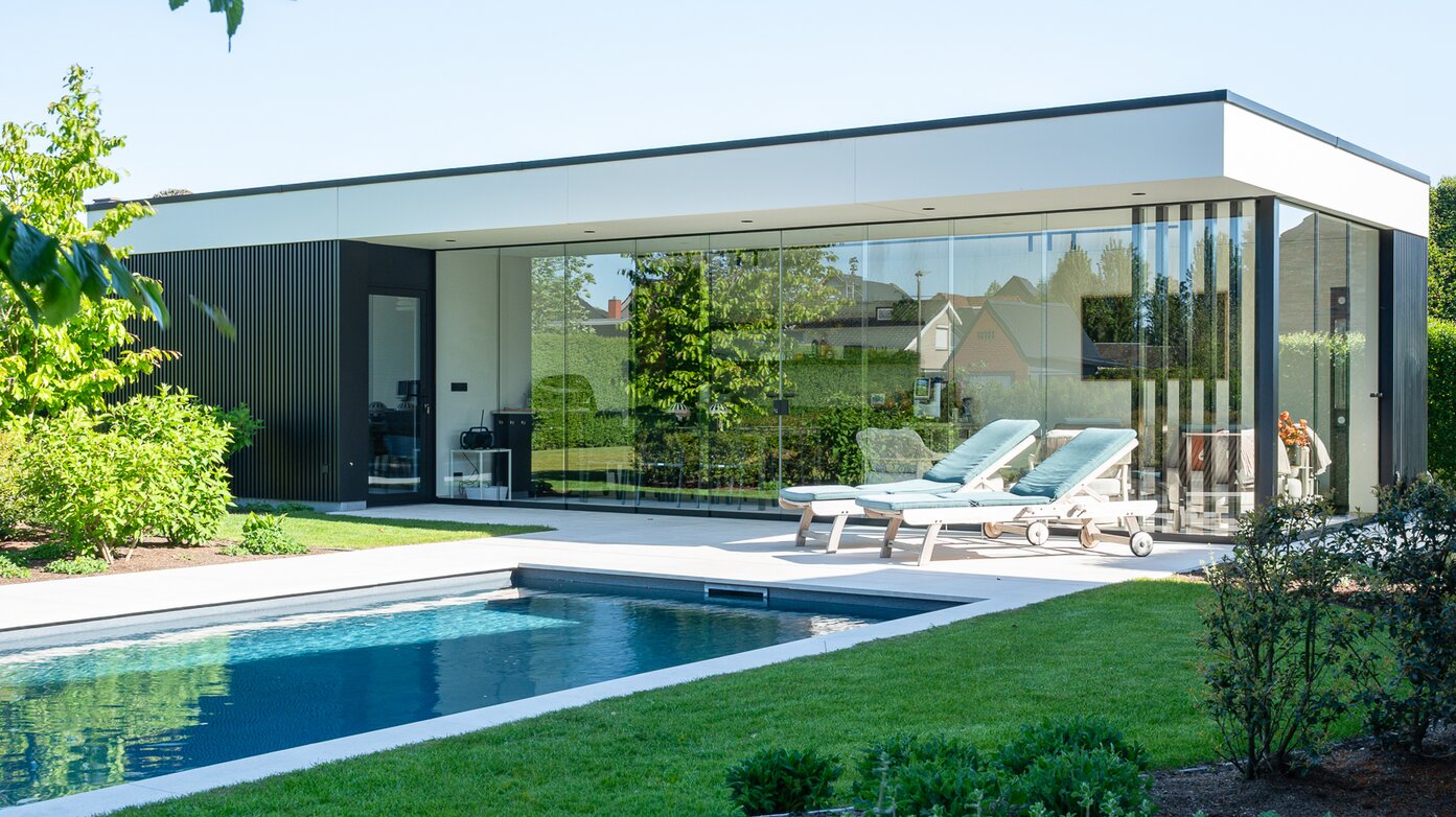 Moderne poolhouse van GC Architecten met glazen gevels en zwembad in groene tuin